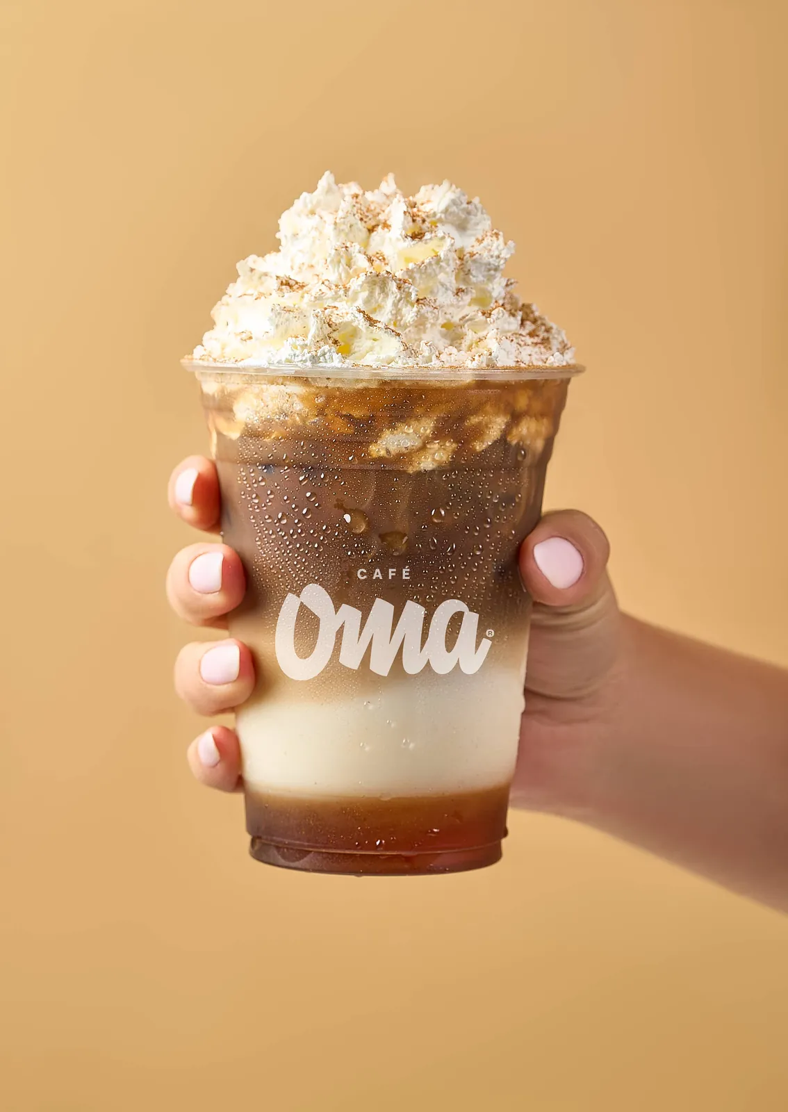 Bebida de Café Oma en mano, fotografía de producto alimenticio