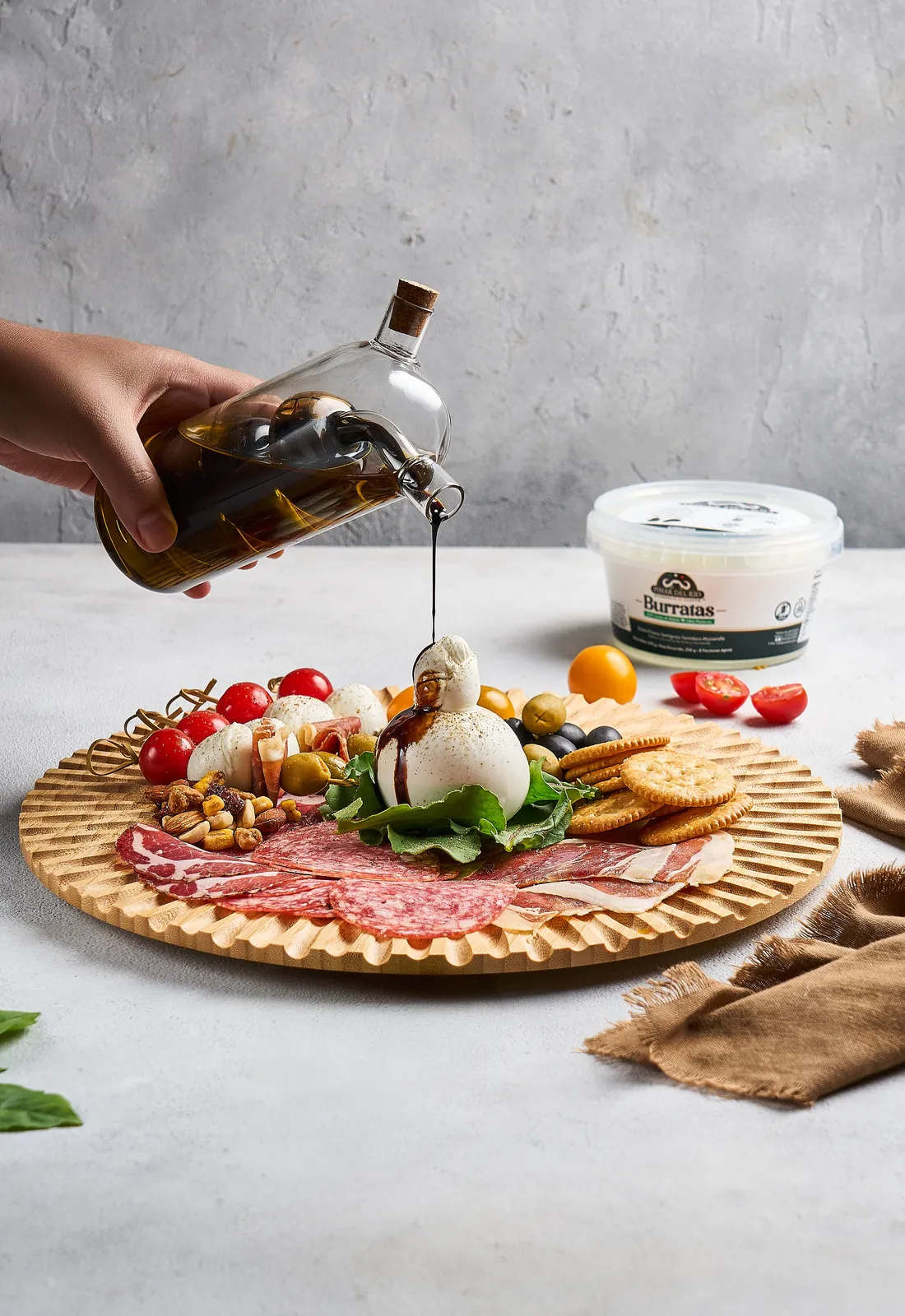 Tabla de antipasto con aceite de oliva sirviéndose